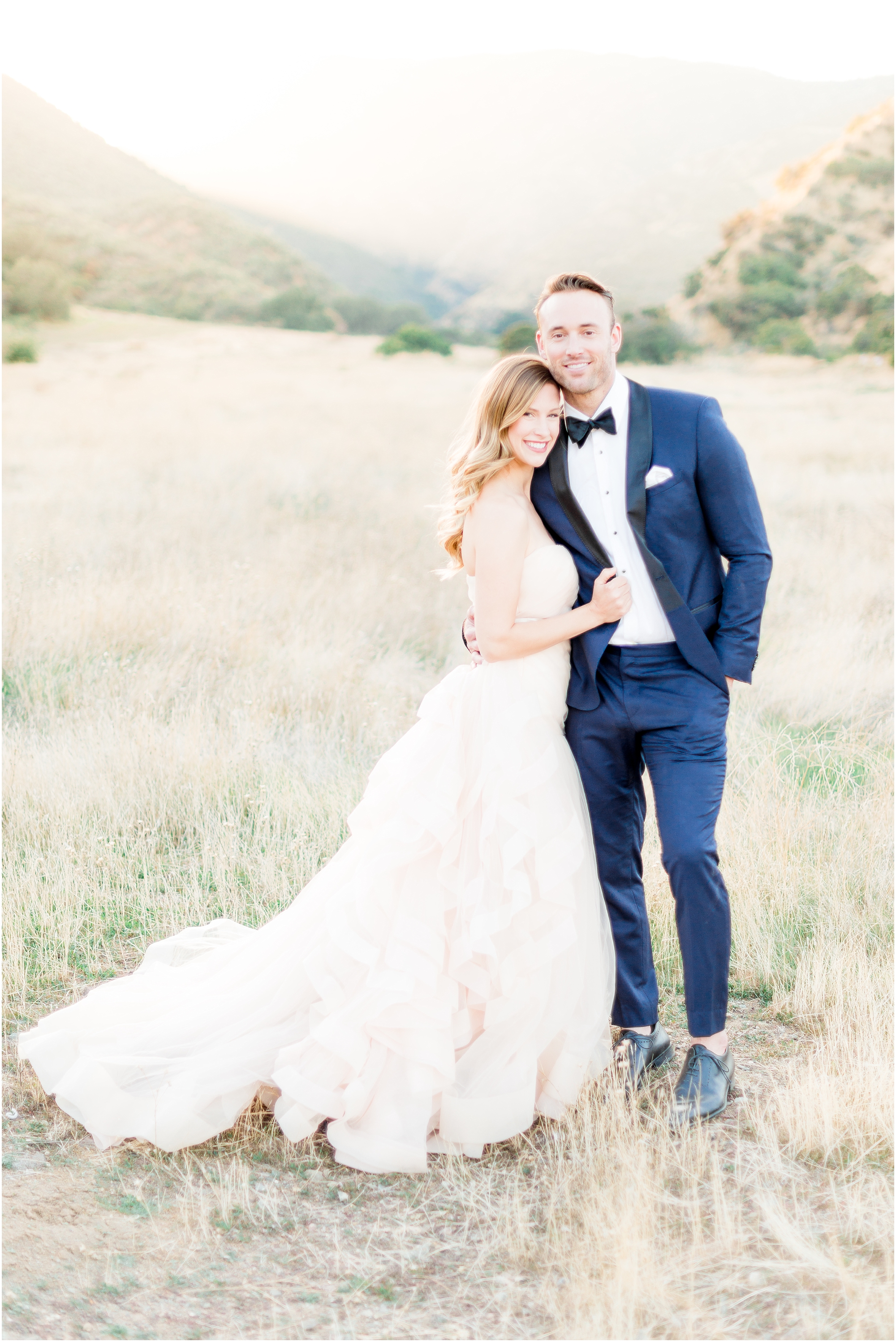 Wedding Photographer in temecula | bride and groom pose with a blush colored wedding gown 