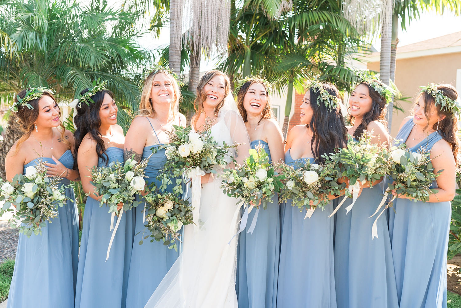 bridesmaids laughing with blue bridesmaid dresses and natural bouquets  bridal party photos